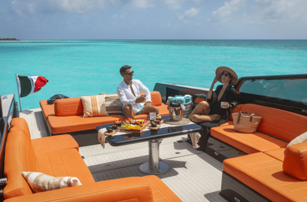 couple talks at back of yacht lounge area amidst clear waters